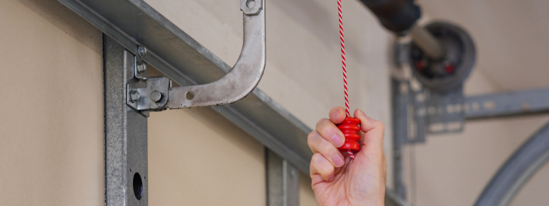 Person pulling a Garage Door release cord during a power outage